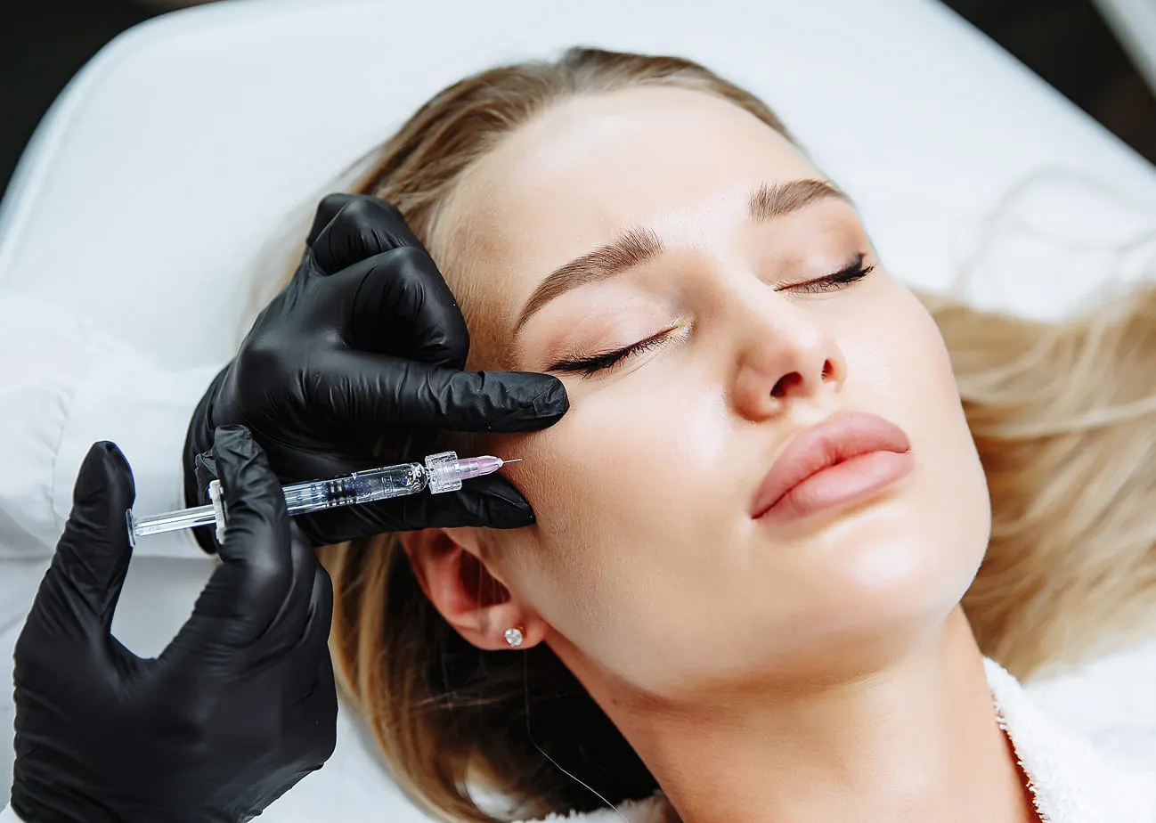 Woman receiving a cosmetic facial injection from an aesthetic professional in a clinical setting