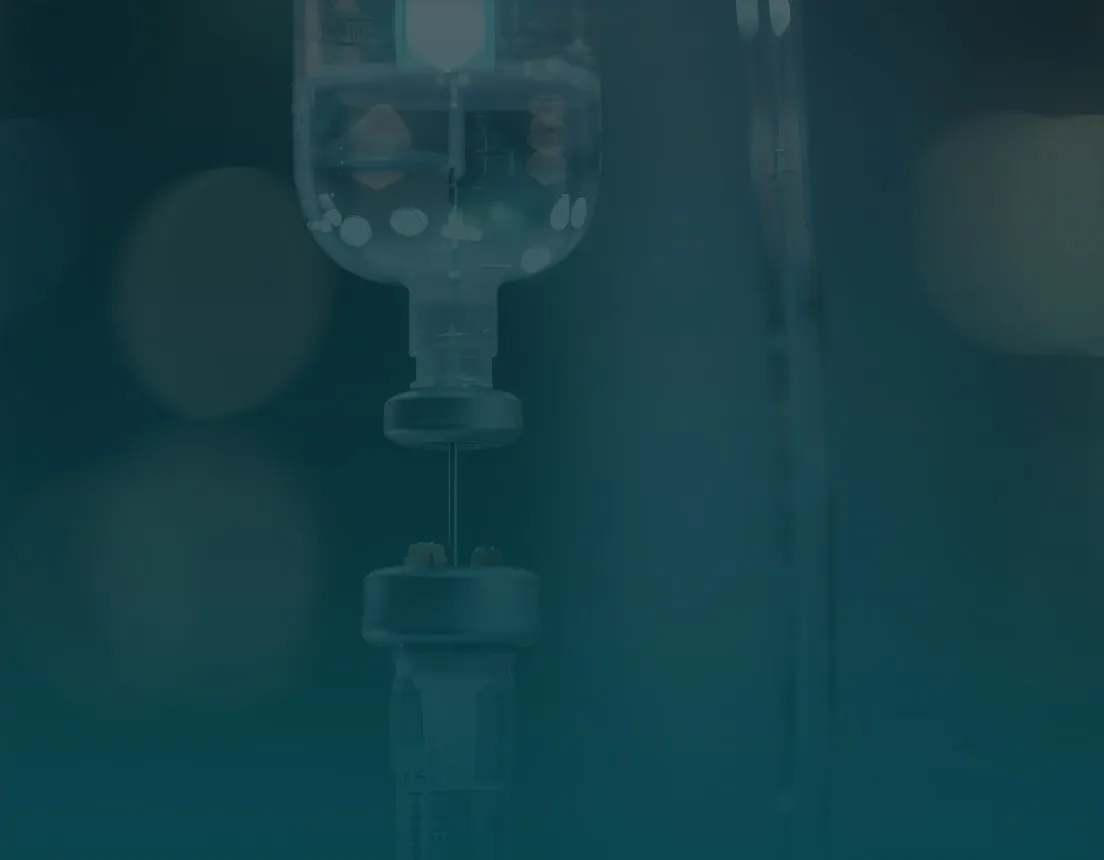 Gloved hand preparing IV infusion bag for medical infusion therapy