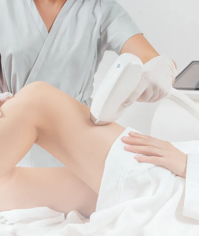 Practitioner performing laser hair removal on a patient's leg in a clinical setting